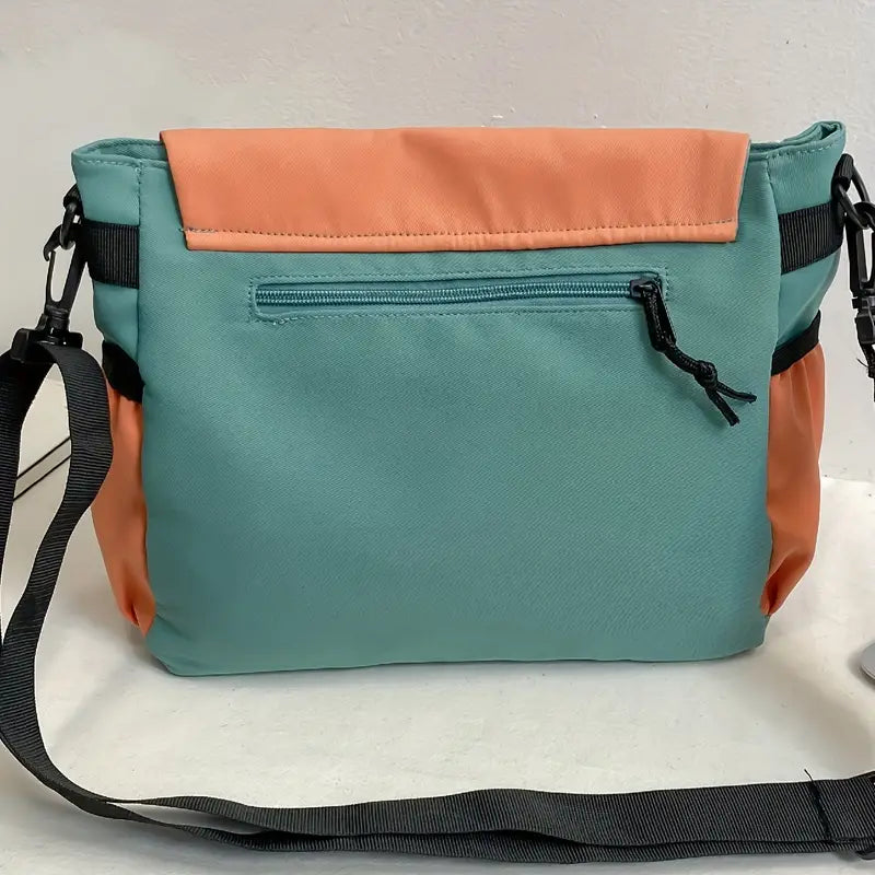 Borsa a tracolla unisex in tessuto bicolore verde e arancione, con tasca frontale con zip e tracolla regolabile. Accessorio moda casual.