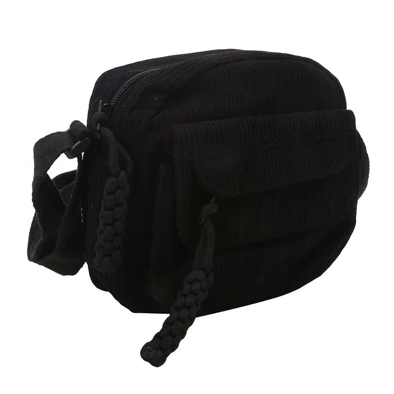 Borsa a tracolla nera in velluto a coste, design compatto con tasca frontale e chiusura a zip. Accessorio moda unisex, ideale per uso quotidiano.