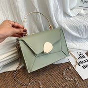Borsa a mano verde salvia con manico dorato e tracolla a catena, design elegante e moderno, perfetta per moda donna e accessori di tendenza.