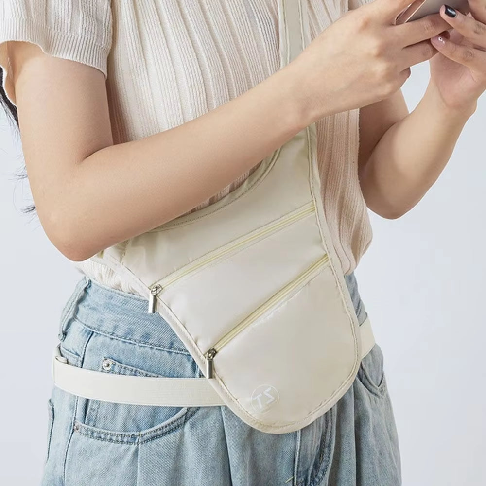 Donna con marsupio bianco a tracolla, indossa jeans e maglietta bianca, utilizza smartphone. Accessorio moda casual, pratico per viaggi e passeggiate.