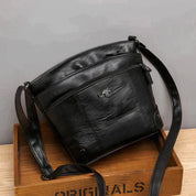 Borsa a tracolla in pelle nera, design elegante e moderno, con cerniera e logo inciso, ideale per moda donna e accessori di lusso.