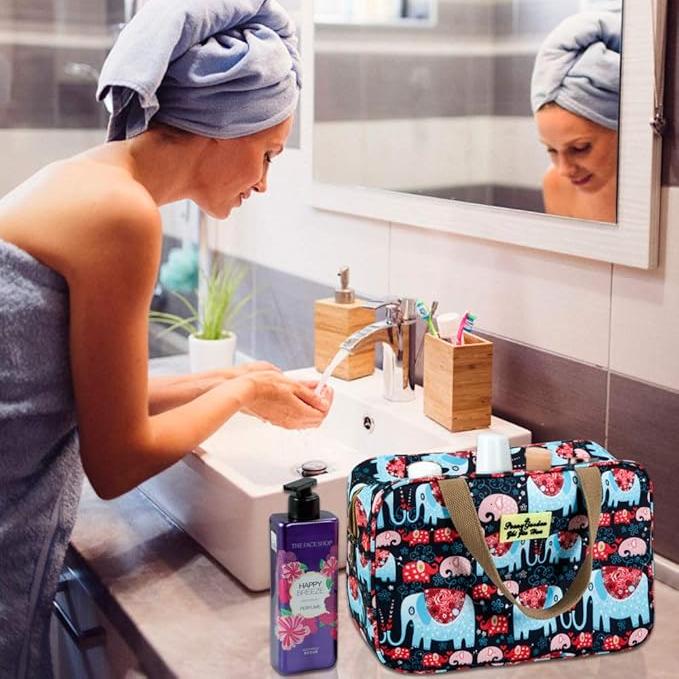 Donna in bagno con asciugamano, borsa da toilette con elefanti, sapone liquido e spazzolini. Accessori bagno colorati e pratici.