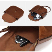 Borsa a tracolla in pelle marrone con chiusura a bottone, scomparto interno contenente chiavi, rossetto e accessori. Elegante e pratica per l'uso quotidiano.