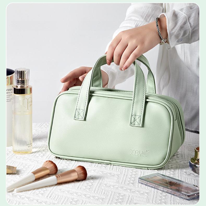 Borsa cosmetica verde menta in pelle, elegante e spaziosa, con cerniera e manici. Ideale per organizzare trucchi e accessori da viaggio.