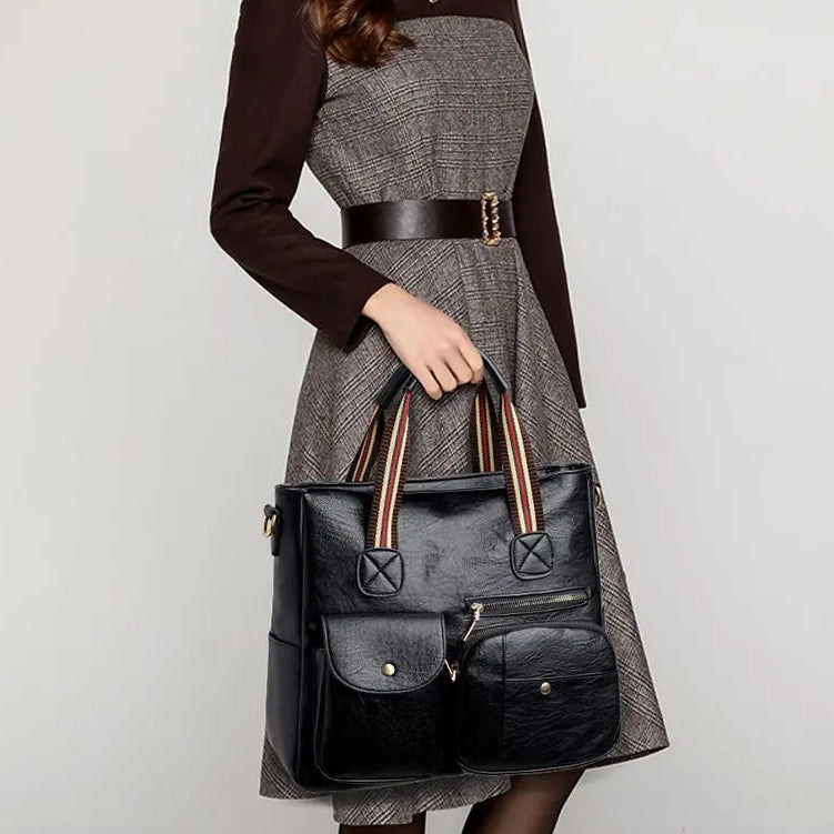 Donna con abito elegante e borsa a mano in pelle nera, tasche frontali, manici a righe. Accessorio moda femminile, stile classico e chic.