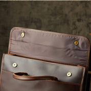 Borsa in pelle marrone aperta, design elegante con chiusure magnetiche, ideale per lavoro e viaggio. Accessorio moda uomo/donna di alta qualità.