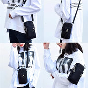Borsa a tracolla nera unisex, compatta e moderna, indossata su maglia bianca con stampa grafica. Accessorio moda casual e versatile.