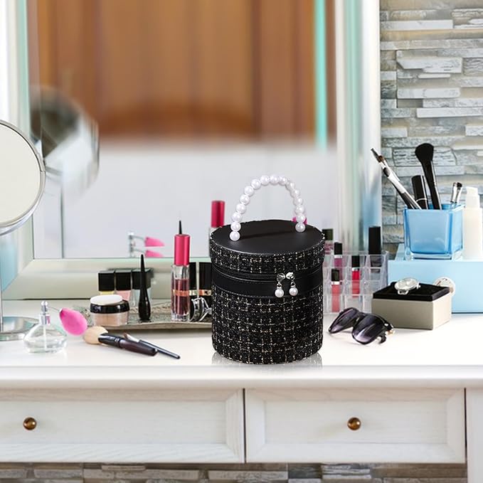 Borsa cosmetica nera con manico di perle su tavolo da trucco, circondata da trucchi e accessori. Elegante organizer per cosmetici.