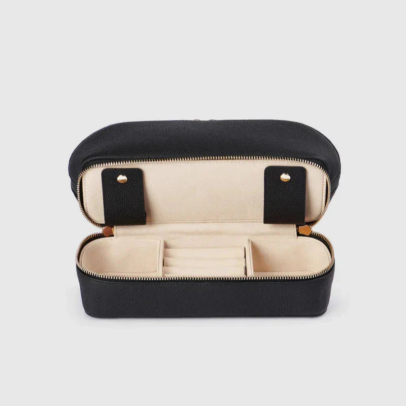 Custodia portagioie in pelle nera aperta, interno beige con scomparti. Elegante e compatta, ideale per viaggi e organizzazione gioielli.