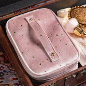 Astuccio cosmetico rosa in velluto con stelle dorate, chiusura a zip, ideale per trucco e accessori, elegante e pratico per viaggi.