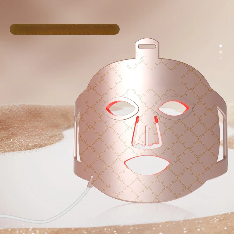 Maschera LED per terapia della pelle, design elegante con motivi dorati, ideale per trattamenti viso anti-età e cura della pelle.
