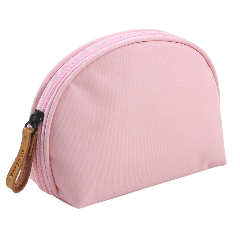 Astuccio cosmetico rosa in tessuto, chiusura con zip e tiralampo in pelle marrone. Ideale per trucco, accessori viaggio, organizer borsa.
