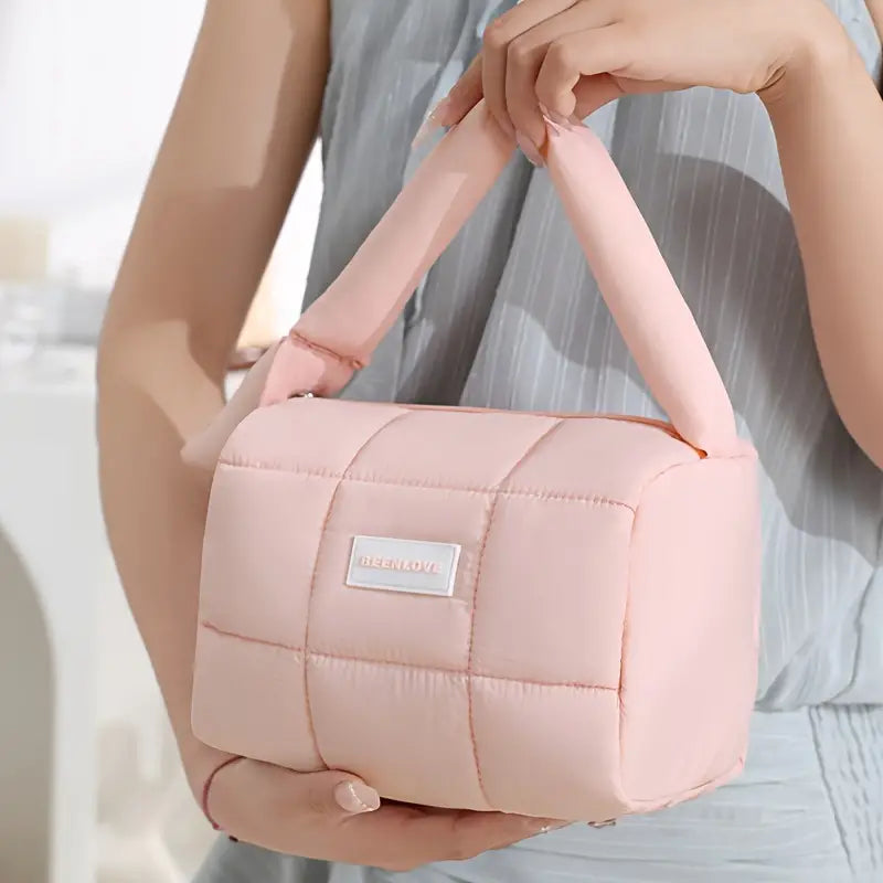 Borsa a mano trapuntata rosa, design moderno, tessuto morbido, manico imbottito, ideale per moda femminile e accessori eleganti.