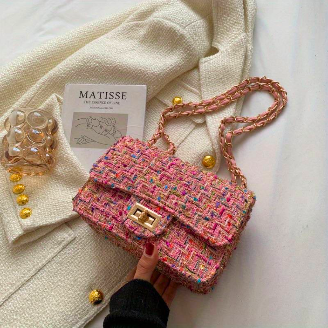 Borsa a tracolla in tweed multicolore su tessuto bianco, con catena dorata e chiusura a scatto. Accessorio moda elegante e chic.