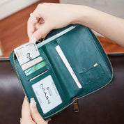 Portafoglio verde in pelle con cerniera, scomparti per carte di credito e banconote, design elegante e funzionale, accessorio moda donna.