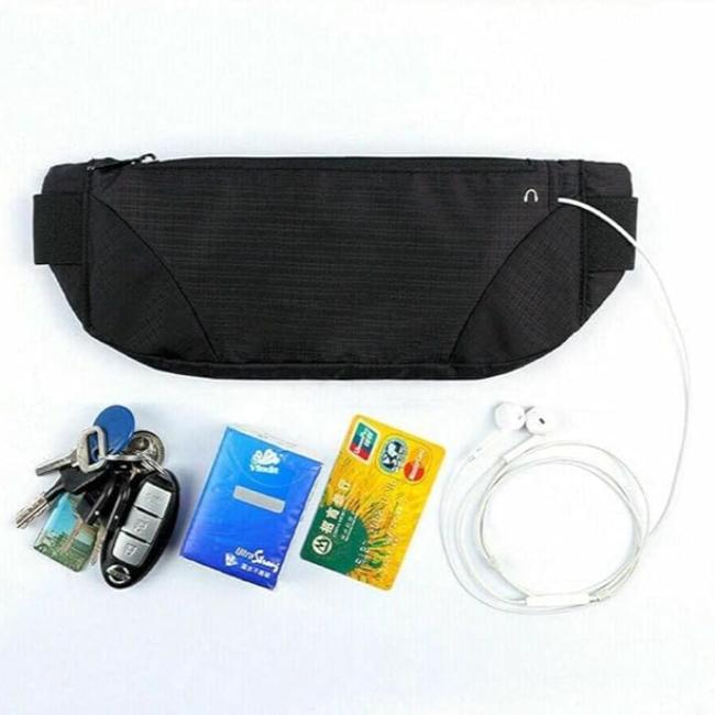 Marsupio nero con cerniera, chiavi, telecomando auto, pacchetto fazzoletti, carta di credito, auricolari bianchi. Accessori viaggio pratici e compatti.