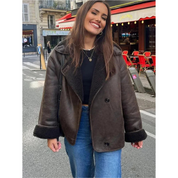 Giacca in pelle marrone da donna, stile casual, indossata su jeans blu. Sfondo urbano con caffè all'aperto. Moda autunnale, look trendy.
