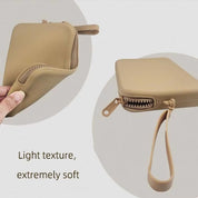 Custodia beige in silicone morbido con cerniera e cinturino, texture leggera. Ideale per protezione dispositivi elettronici.