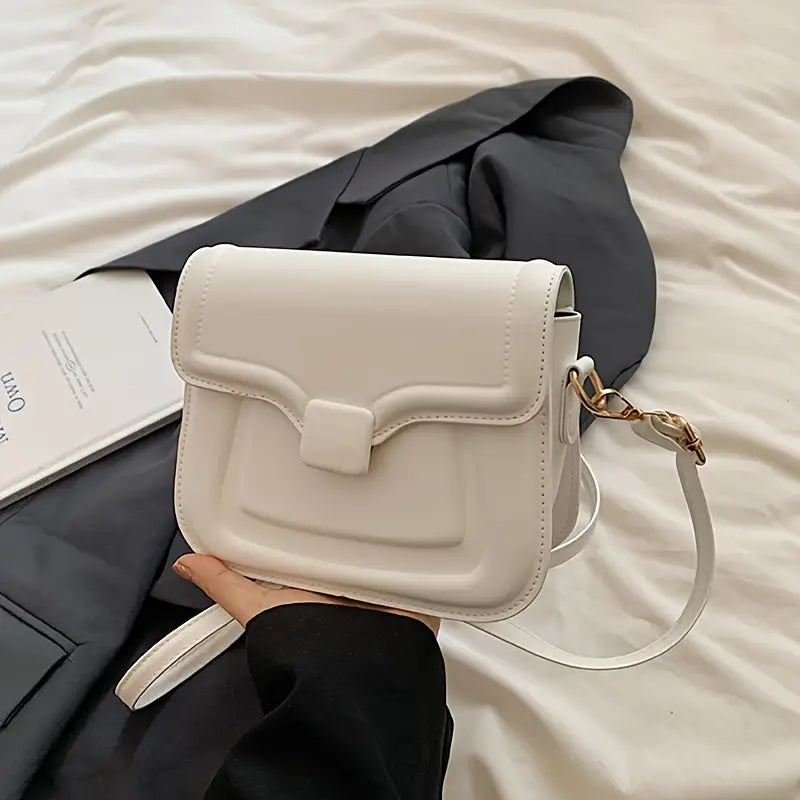 Borsa a tracolla bianca elegante su sfondo nero, design moderno con chiusura a patta, ideale per moda femminile e accessori di tendenza.