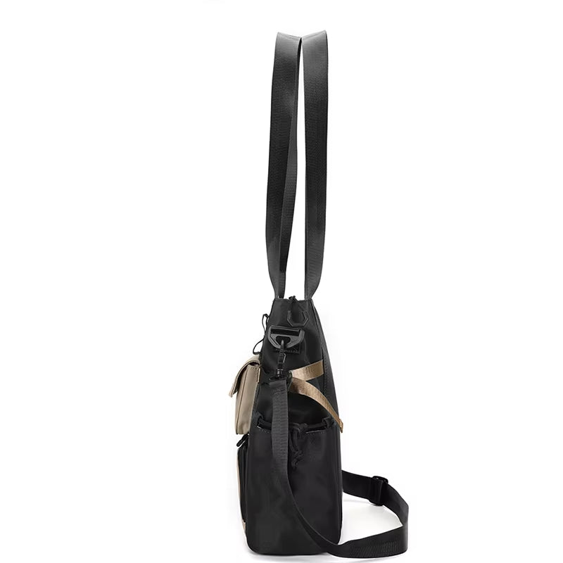 Borsa a tracolla nera in pelle, vista laterale, con manici lunghi e tasche multiple. Design elegante e funzionale per uso quotidiano.