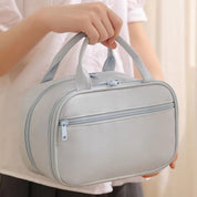 Borsa da toilette grigia con doppia cerniera, manici resistenti, design elegante e compatto. Ideale per viaggi e organizzazione accessori bagno.