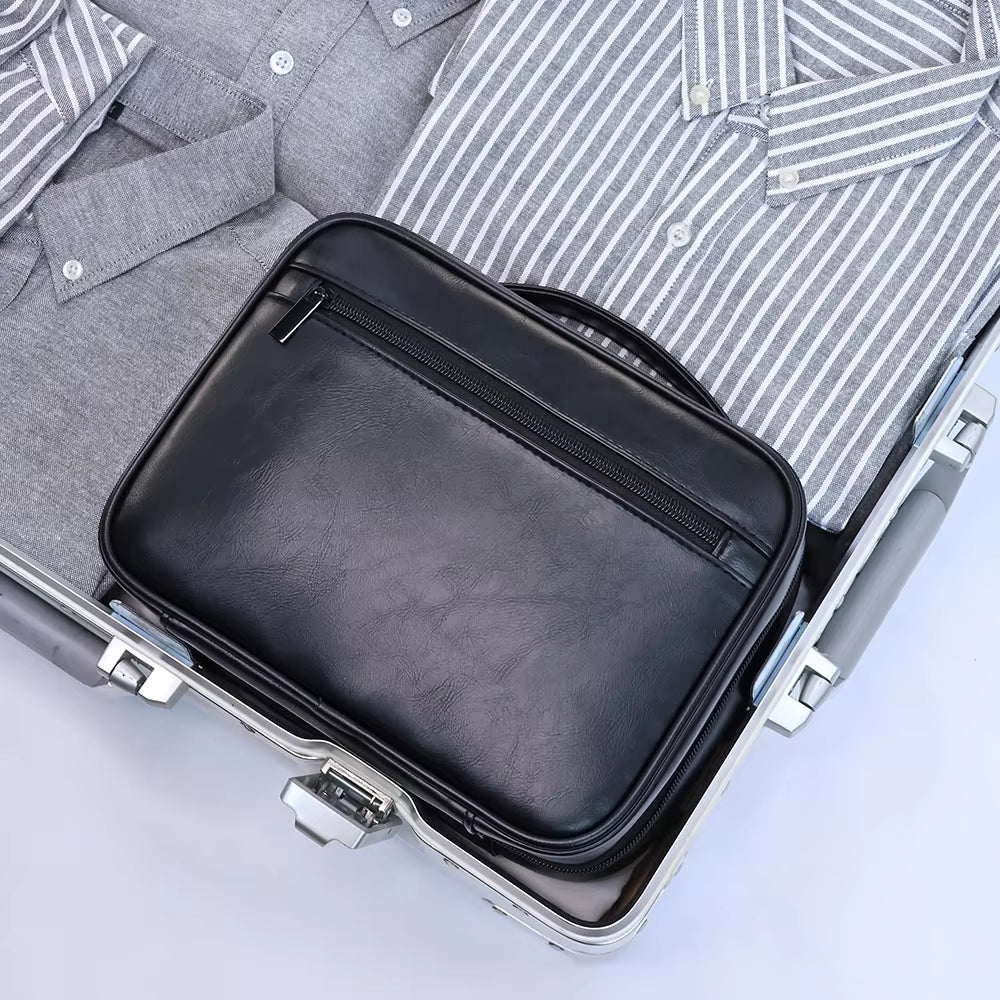 Valigia aperta con camicie grigie piegate e borsa in pelle nera. Accessori da viaggio eleganti, organizzazione bagaglio, moda uomo.