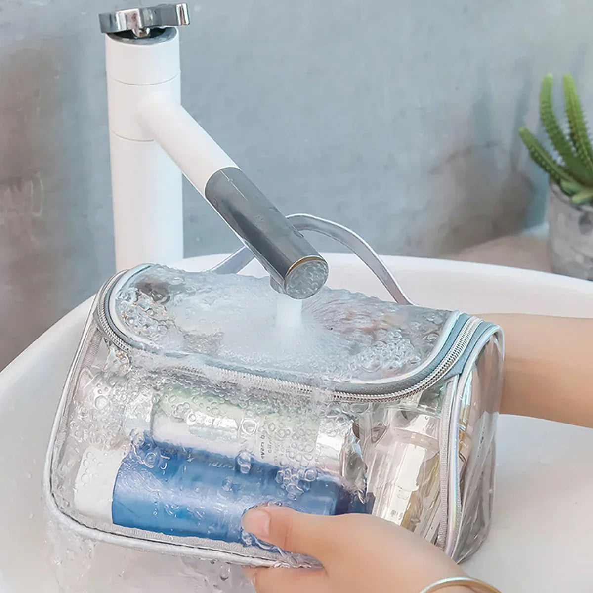 Borsa da toilette trasparente impermeabile sotto rubinetto, contenente prodotti cosmetici. Ideale per viaggi, resistente all'acqua, pratica e versatile.