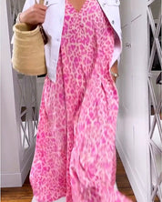 Abito lungo rosa leopardato, giacca bianca, borsa di paglia. Moda estiva donna, look casual chic, tendenze abbigliamento 2023.