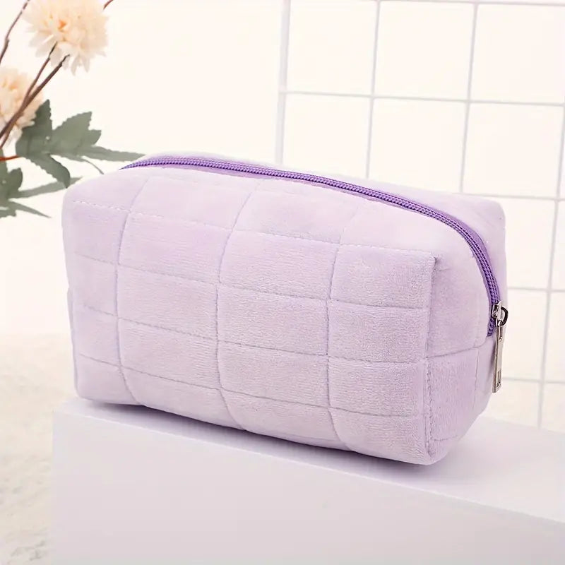 Astuccio cosmetico viola in velluto, design trapuntato, chiusura con cerniera, ideale per trucco e accessori, elegante e pratico.