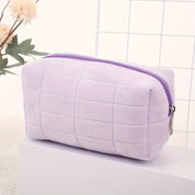 Astuccio cosmetico viola in velluto, design trapuntato, chiusura con cerniera, ideale per trucco e accessori, elegante e pratico.