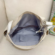 Borsa a tracolla beige aperta, interno spazioso con tasca grigia, design elegante e funzionale, ideale per uso quotidiano e viaggi.