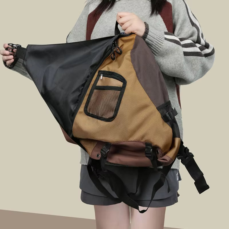 Zaino triangolare unisex in tessuto multicolore con tasca frontale a rete, indossato da una persona. Design moderno, ideale per viaggi e attività outdoor.