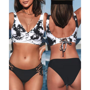 Bikini donna bianco e nero, top incrociato con stampa tie-dye, slip con lacci laterali. Costume da bagno estivo, moda mare 2023.