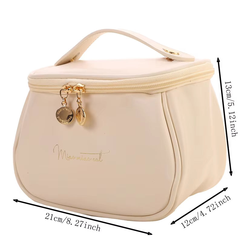 Borsa cosmetica beige con cerniera dorata, manico superiore e dimensioni 21x12x13 cm. Elegante e pratica per viaggi e organizzazione trucco.