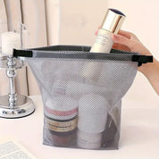 Borsa organizer in rete trasparente con prodotti cosmetici, ideale per viaggi. Design pratico, resistente e leggero. Accessorio essenziale da bagno.