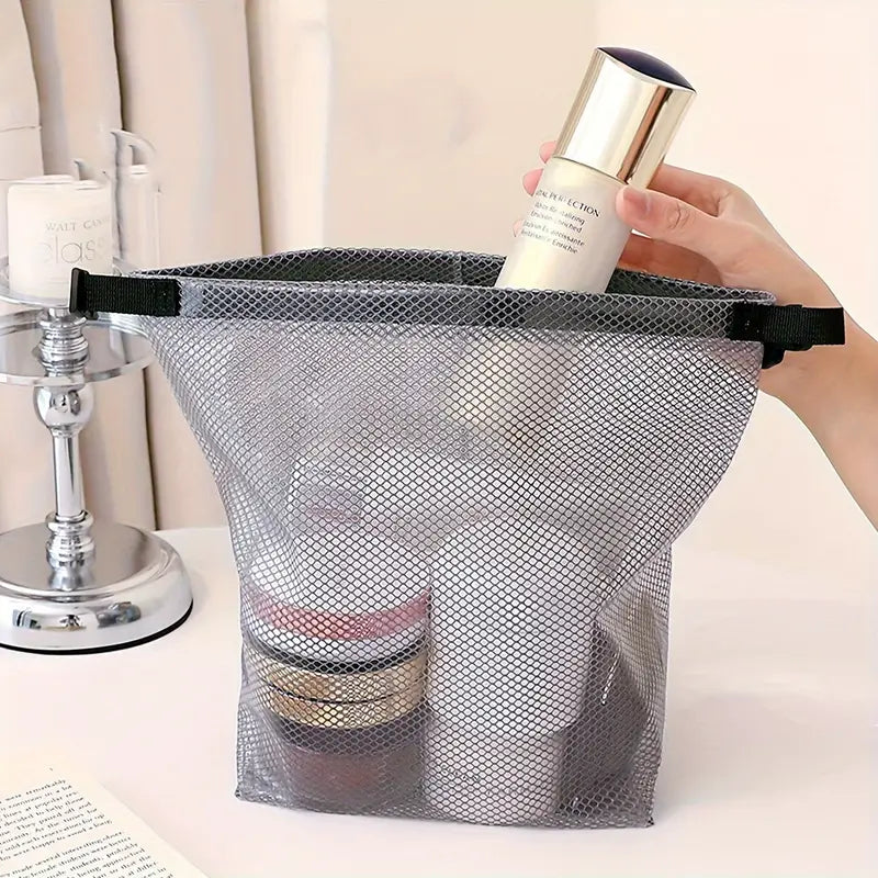 Borsa organizer in rete trasparente con prodotti cosmetici, ideale per viaggi. Design pratico, resistente e leggero. Accessorio essenziale da bagno.