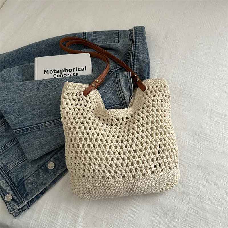 Borsa a rete in cotone beige con manici in pelle su giacca di jeans e libro, moda sostenibile, accessori donna, stile casual chic.