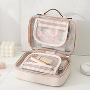 Borsa cosmetica rosa aperta con scomparti trasparenti, contenente accessori trucco e cura personale. Ideale per organizzare prodotti di bellezza.