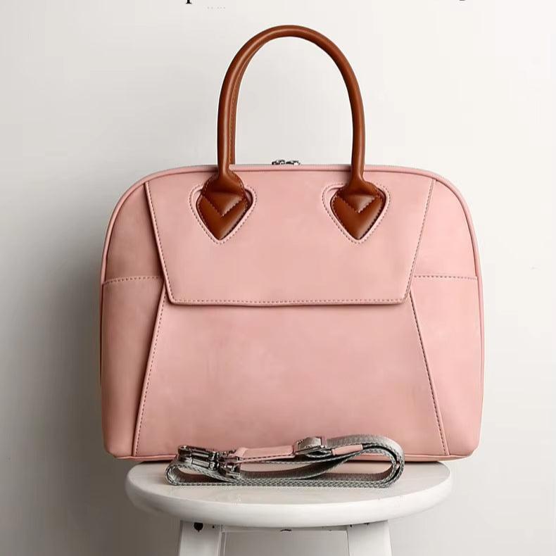 Borsa a mano rosa in pelle con manici marroni, design elegante, perfetta per moda femminile, accessorio di tendenza, su sgabello bianco.