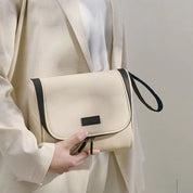 Borsa a tracolla beige elegante, design minimalista, chiusura con zip, manico nero, ideale per moda donna, accessorio versatile e chic.