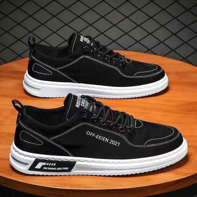 Scarpe da ginnastica nere da uomo su tavolo in legno, design moderno con suola bianca, cuciture a contrasto, marchio visibile. Scarpe casual eleganti.