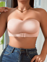 Reggiseno senza spalline color nude, design liscio, chiusura frontale, indossato con jeans. Intimo femminile elegante e confortevole.