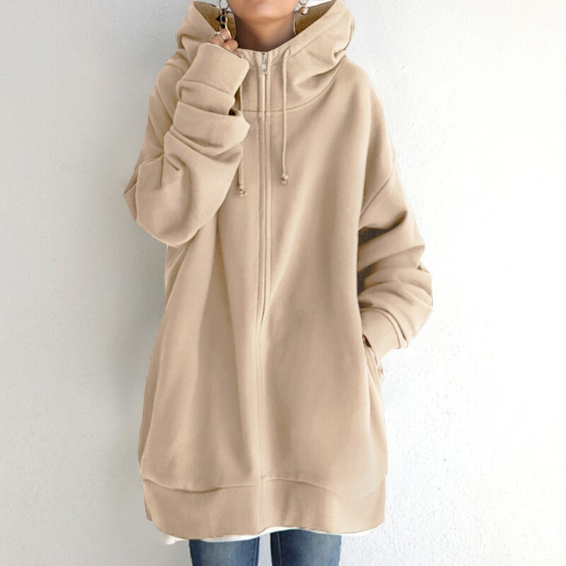 Felpa oversize beige con cappuccio, zip frontale e tasche, indossata da una persona. Stile casual, ideale per moda autunnale e invernale.