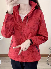 Giacca a vento rossa con motivo floreale, chiusura zip, tasche laterali, indossata da una persona. Ideale per attività all'aperto e sport.