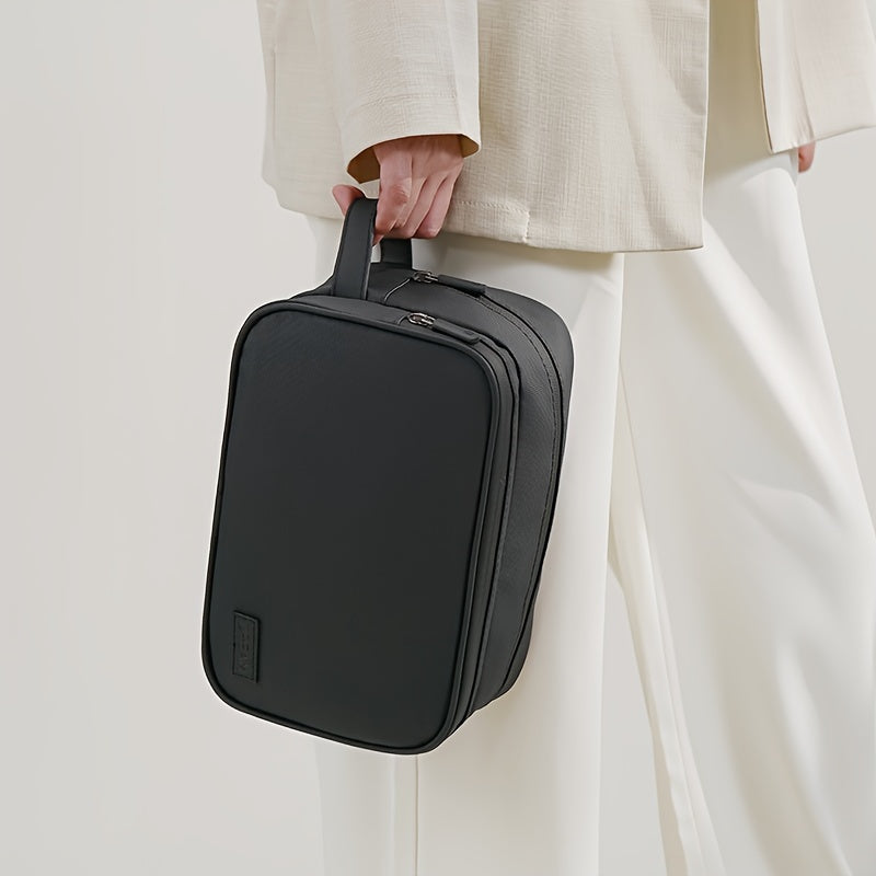 Borsa a mano nera elegante, design minimalista, portata da una persona in abbigliamento chiaro. Ideale per lavoro e viaggi.