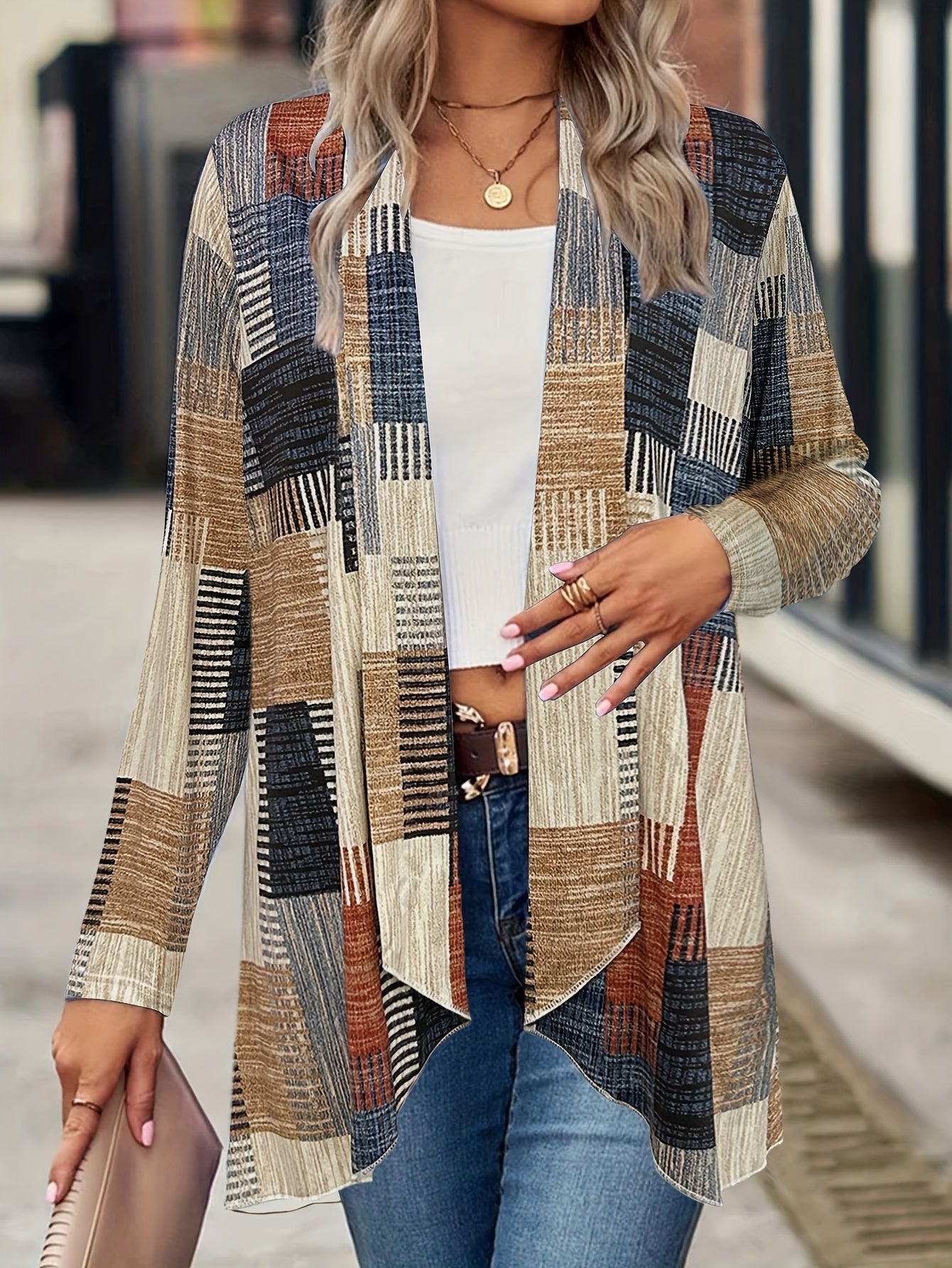 Donna con cardigan a quadri multicolore, top bianco e jeans. Moda autunnale, abbigliamento casual elegante, accessori dorati.