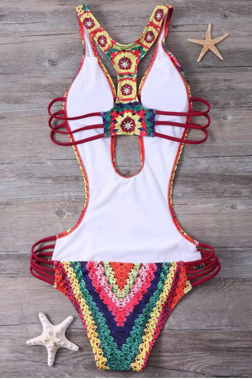 Costume da bagno intero crochet multicolore su sfondo legno, dettagli a stella marina. Design estivo, moda mare, tendenza beachwear 2023.