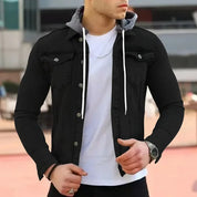 Giacca di jeans nera da uomo con cappuccio grigio, indossata sopra una maglietta bianca. Moda casual maschile, abbigliamento autunnale.
