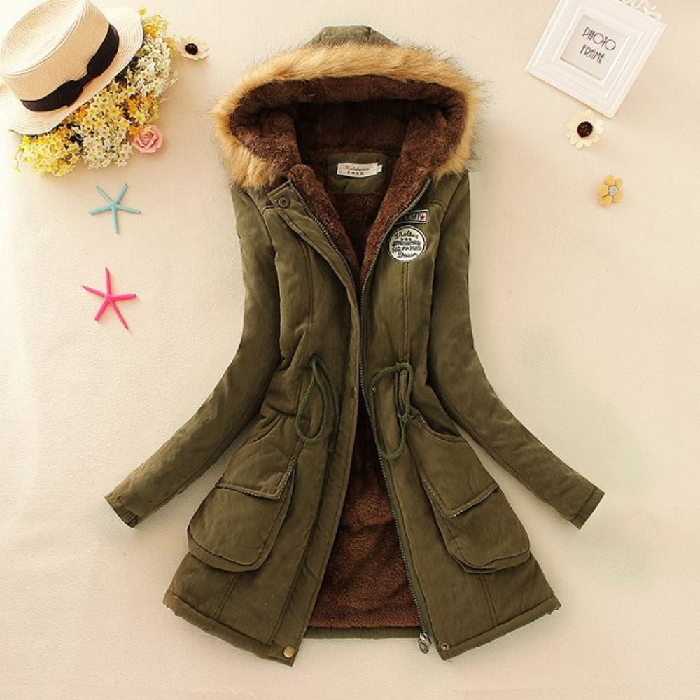 Giacca invernale verde con cappuccio in pelliccia sintetica, chiusura a zip, tasche frontali e dettagli decorativi. Elegante e calda per l'inverno.