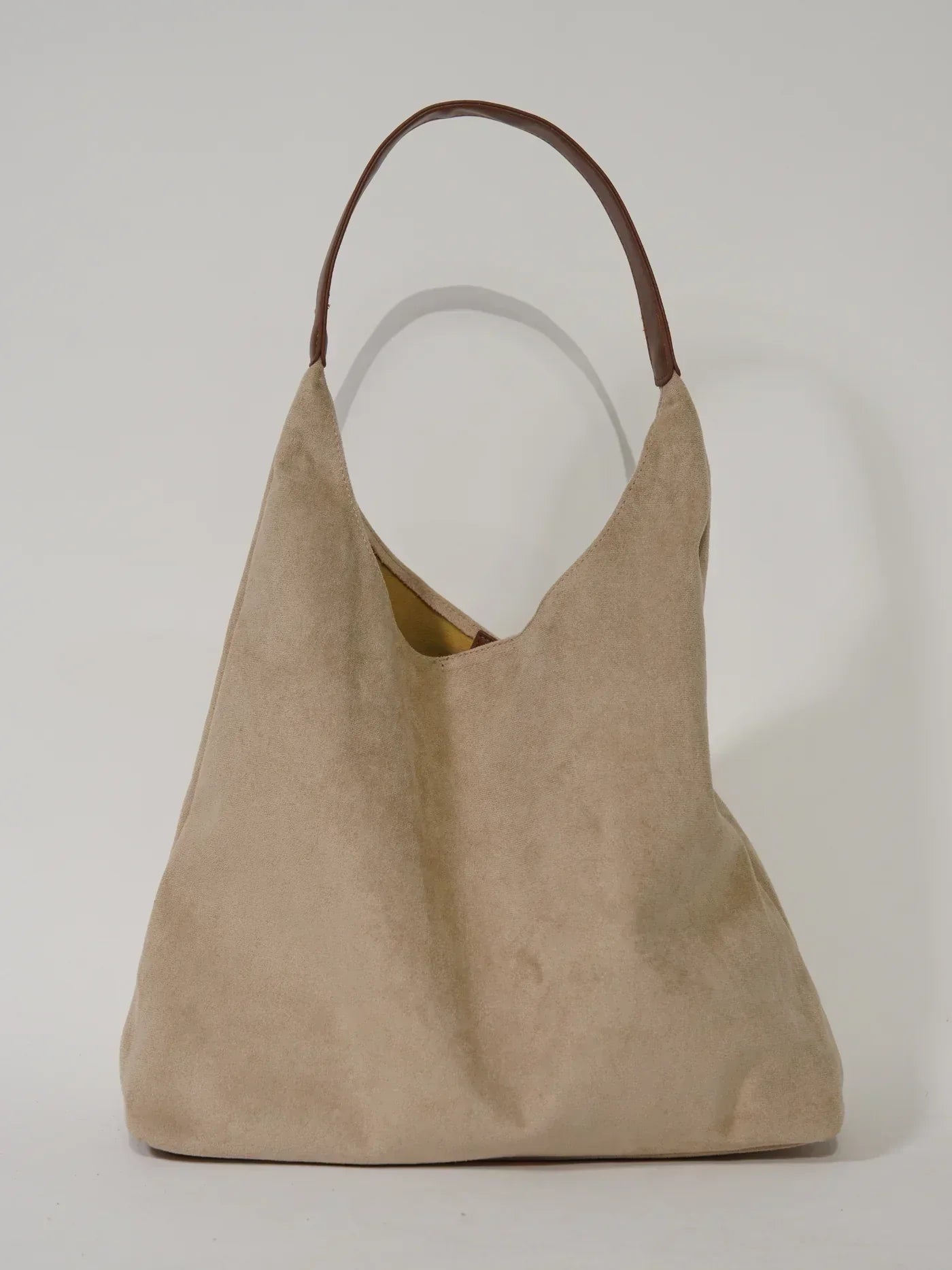 Borsa a spalla in pelle scamosciata beige con manico marrone, design minimalista. Accessorio moda elegante e versatile per ogni occasione.